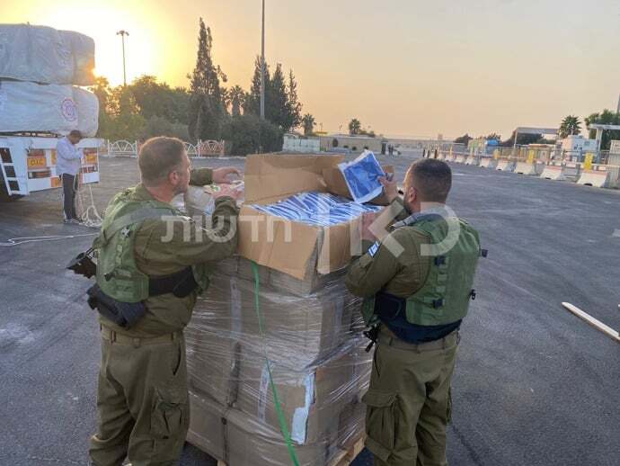 صورة تظهر ضباطا إسرائيليين يفحصون المساعدات القادمة من مصر.